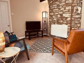 A living room with a television and chairs at Coach House near St Clears