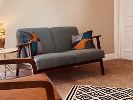 A living room with a sofa and a side table at Coach House near St Clears