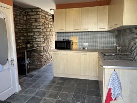 A kitchen with cabinets and a microwave at Coach House near St Clears