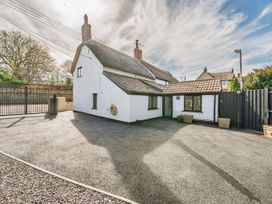 An outdoor view of a house with a garden and gate at Bridge Cottage in Chideock