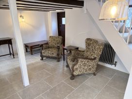 A living room with chairs and a table at Bridge Cottage in Chideock