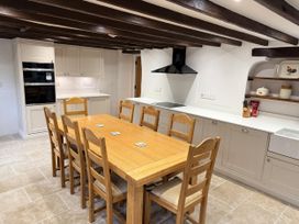 A kitchen with a wooden dining table and chairs at Bridge Cottage in Chideock
