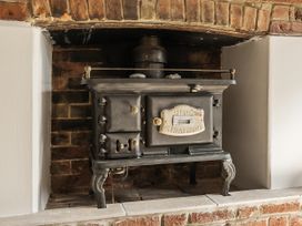 A wood stove in a brick alcove at Bridge Cottage in Chideock