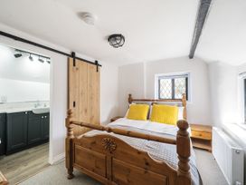 A bedroom with a bed and sliding door to the bathroom at Bridge Cottage in Chideock