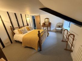 A bedroom with a bed and dressing table at Bridge Cottage in Chideock