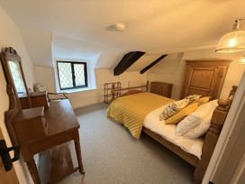 A bedroom with a bed and furniture at Bridge Cottage in Chideock