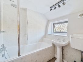 A bathroom with a bathtub, sink, and toilet at Bridge Cottage in Chideock
