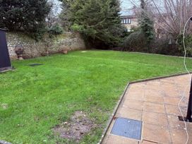 A garden with grass and pavers at Bridge Cottage in Chideock