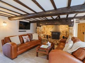 A living room with sofas and a fireplace at Bridge Cottage in Chideock