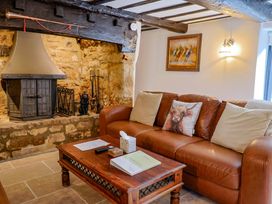 A living room with a sofa and fireplace at Bridge Cottage in Chideock