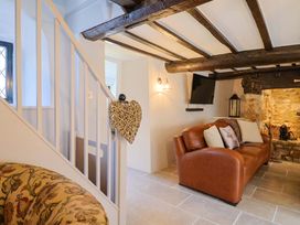 A living room with a couch and a television at Bridge Cottage in Chideock