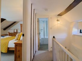 A hallway with access to a bedroom and bathroom at Bridge Cottage in Chideock