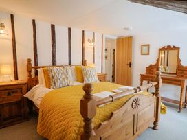 A bedroom with a bed, dresser, and mirror at Bridge Cottage in Chideock