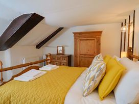A bedroom with a bed, wardrobe, and cabinet at Bridge Cottage in Chideock
