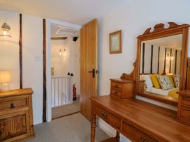 A bedroom with a wooden dresser and mirror at Bridge Cottage in Chideock