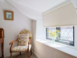 A seating area with a chair and flower vase at Bridge Cottage in Chideock