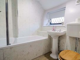 A bathroom with a bathtub, sink, and toilet at Bridge Cottage in Chideock