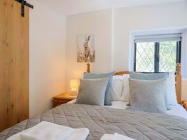 A bedroom with a bed and lamp at Bridge Cottage in Chideock