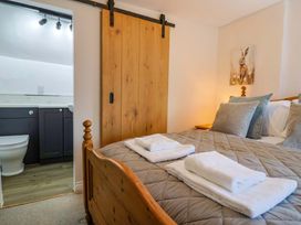A bedroom with a bed and bathroom visible at Bridge Cottage in Chideock