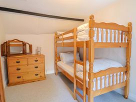 A bedroom with a bunk bed and a chest of drawers at Bridge Cottage in Chideock