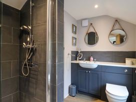 A bathroom with a shower, sink, and toilet at Bridge Cottage in Chideock