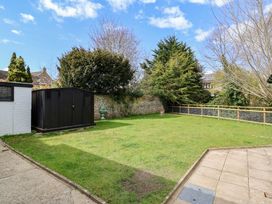 A garden with a shed and lawn at Bridge Cottage in Chideock