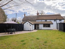 A garden with a patio and dining set at Bridge Cottage in Chideock