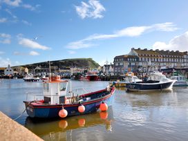 A harbor with fishing boats and buildings at Bridge Cottage in Chideock