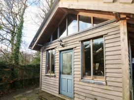 A wooden cabin with a blue door and large windows at the Cabin in Newport