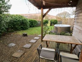 A garden with a table, chairs, hot tub and gravel at Cabin in Newport