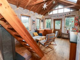 A living room with wooden stairs and furniture at Cabin in Newport