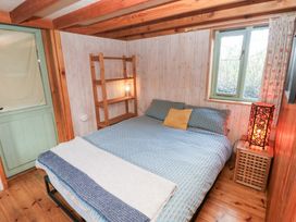 A bedroom with a bed and wooden shelf at Cabin in Newport