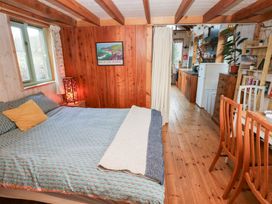 A bedroom with a bed and kitchen area at Cabin in Newport