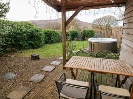 A garden with a hot tub and seating area at Cabin in Newport
