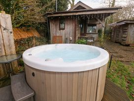 A hot tub near a wooden cabin at Cabin in Newport