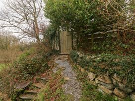 A pathway leading to a gate surrounded by greenery at the Cabin in Newport