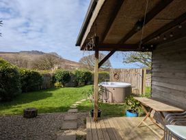 A garden with a hot tub and seating area at Cosy Eco Cabin in Cilgwyn near Newport, Pembrokeshire