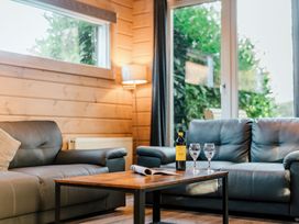 A living room with a table, sofa, and wine at Poplar Lodge (Pet) Thirsk