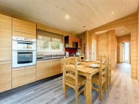 A kitchen with wooden furniture and appliances at Poplar Lodge (Pet) Thirsk