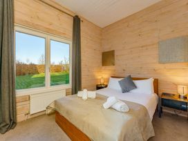 A bedroom with a bed and window at Poplar Lodge (Pet) Thirsk