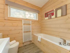 A bathroom with a bathtub and a toilet at Poplar Lodge (Pet) Thirsk