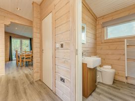 A bathroom with a toilet and sink leading to a dining area at Poplar Lodge (Pet) Thirsk
