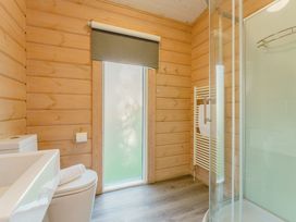 A bathroom with a toilet, sink, shower, and towel rail at Poplar Lodge (Pet) Thirsk