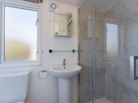 A bathroom with a shower, sink, and window at Spruce Waterside Spa (Pet) Thirsk