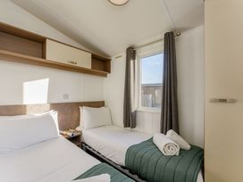 A bedroom with two beds and a window at Spruce Waterside Spa (Pet) Thirsk