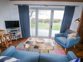 A living room with a sofa and tv at The Faithfuls Cabin in Dingle