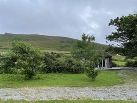 A view of a house with trees and mountains at The Faithfuls Cabin in Dingle, County Kerry