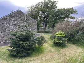 A garden with trees and shrubbery at The Faithfuls Cabin in Dingle, County Kerry