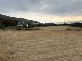 A field with houses and mountains in the background at The Faithfuls Cabin Dingle, County Kerry