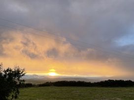 A sunset view with clouds and grassland at The Faithfuls Cabin in Dingle, County Kerry